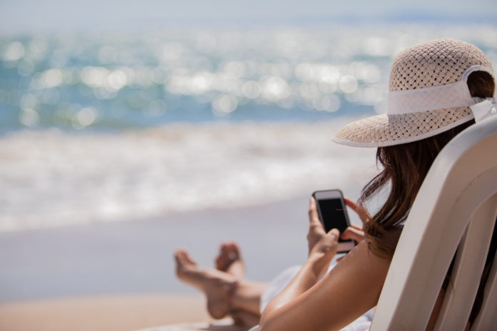 vrouw met telefoon op het strand